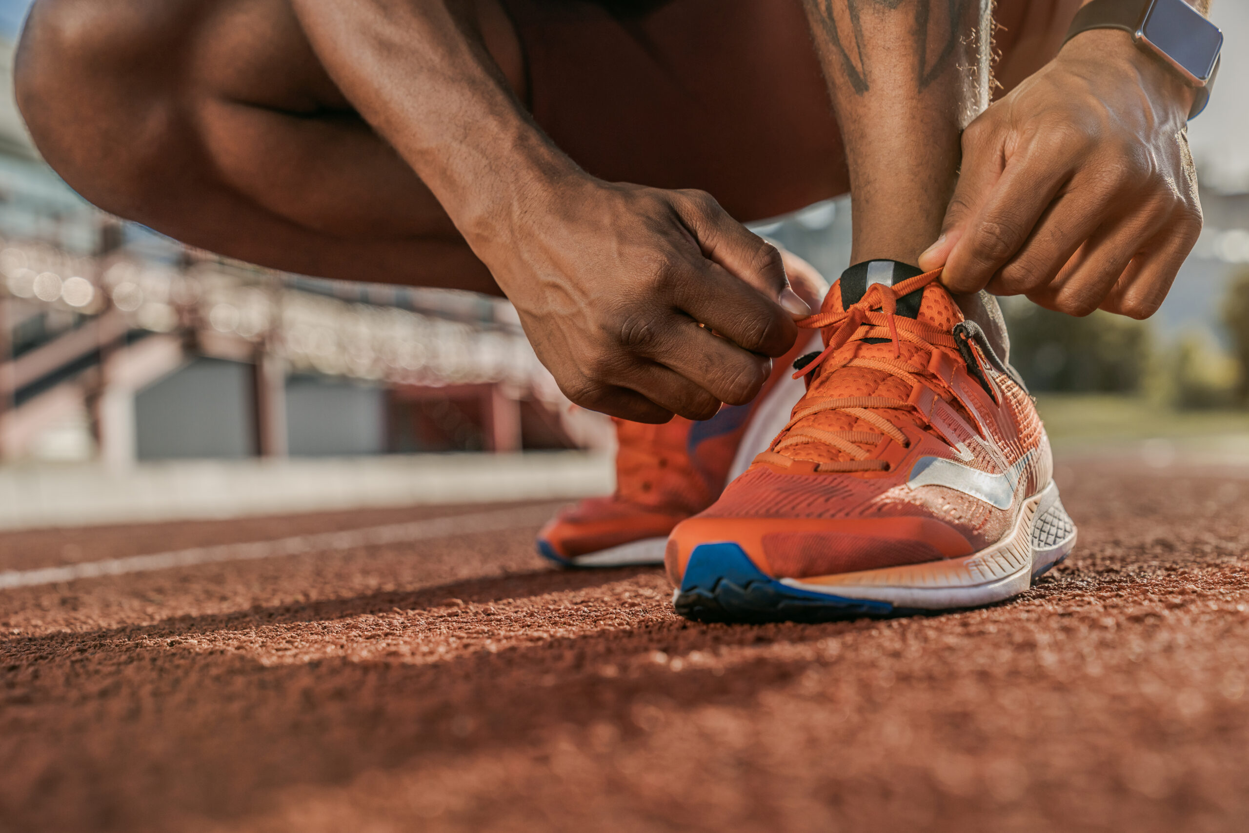 Getting ready to jogging. Close up shot of hands tying shoelaces sneaker on the running track